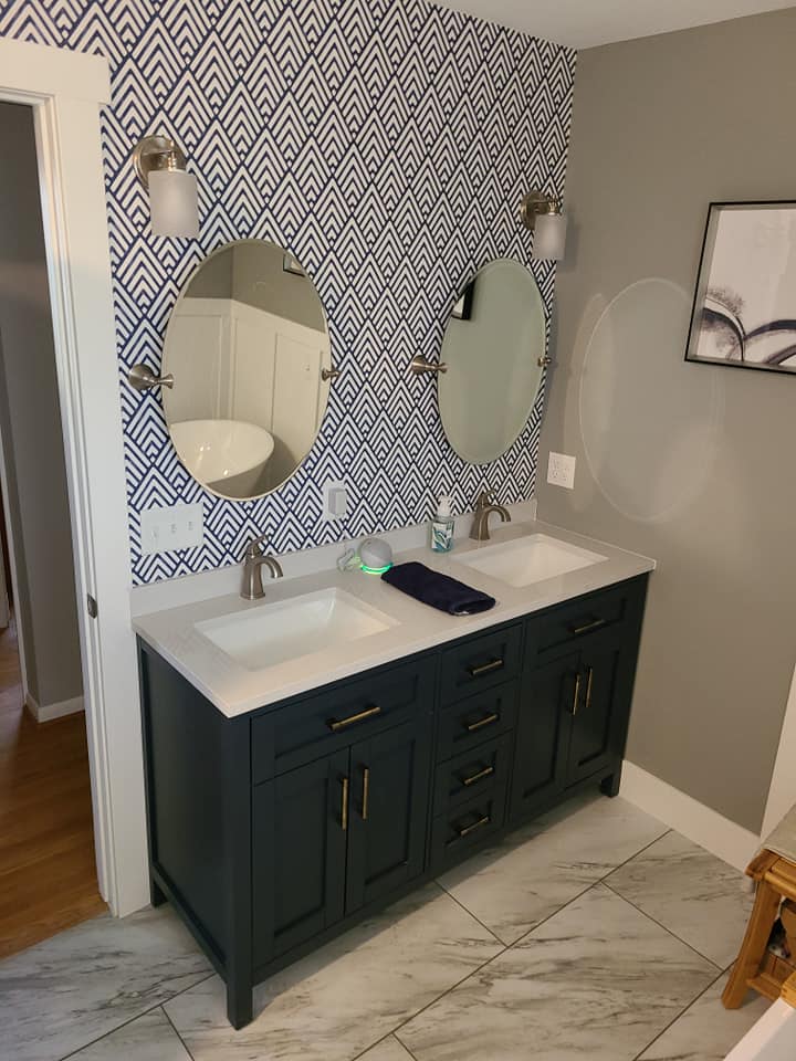 Bathroom double vanity with navy chevron-pattern wallpaper and a white countertop